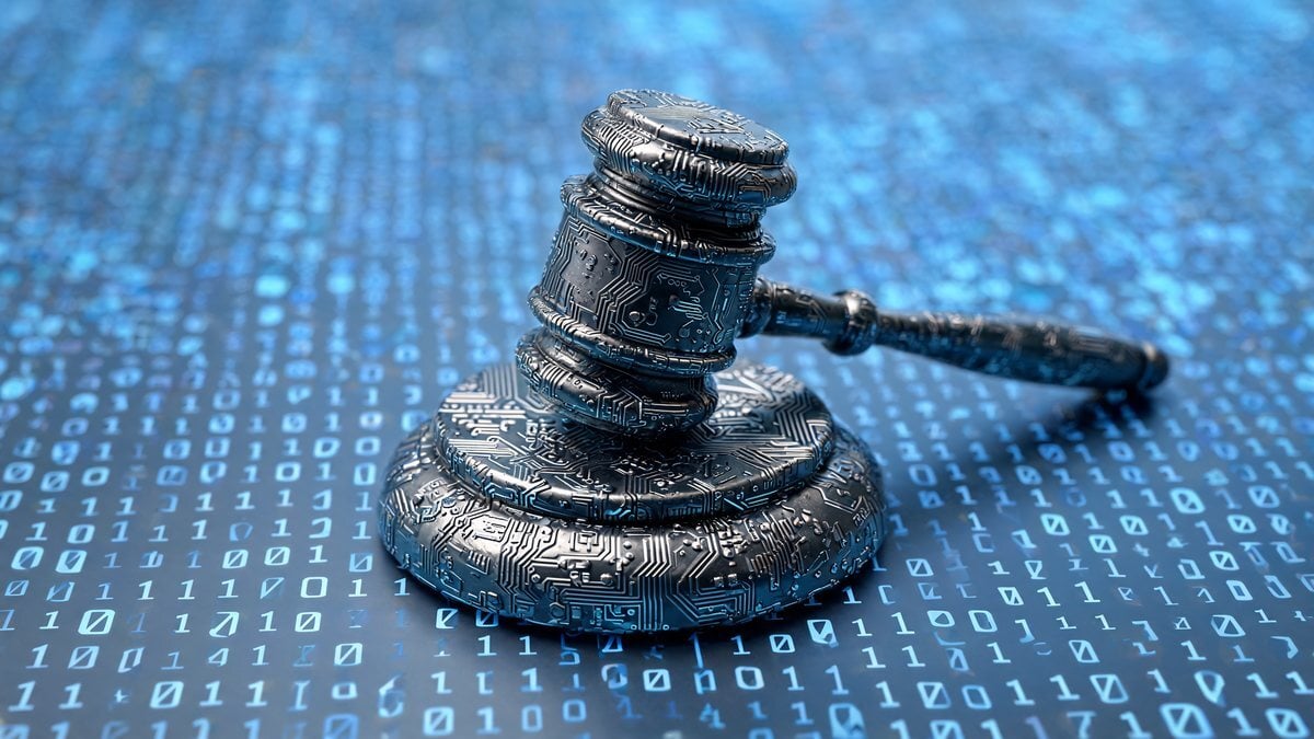 A circuit-board gavel resting on a surface of binary digits