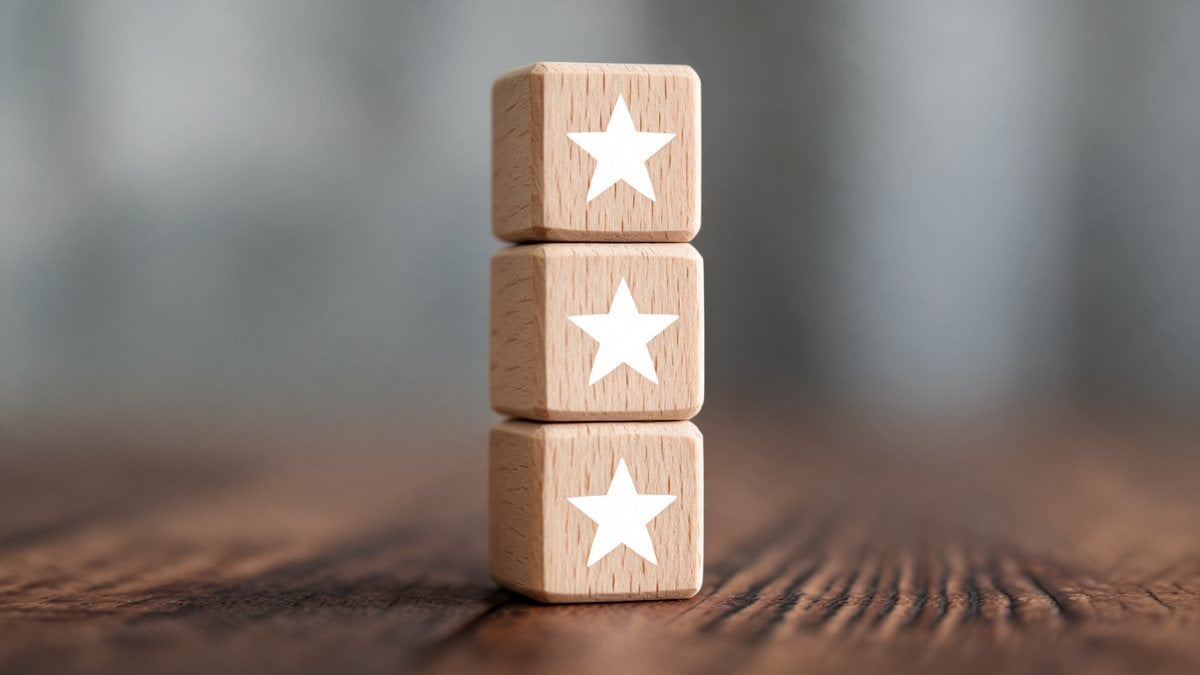 Three stacked wooden cubes marked with stars on a wooden table
